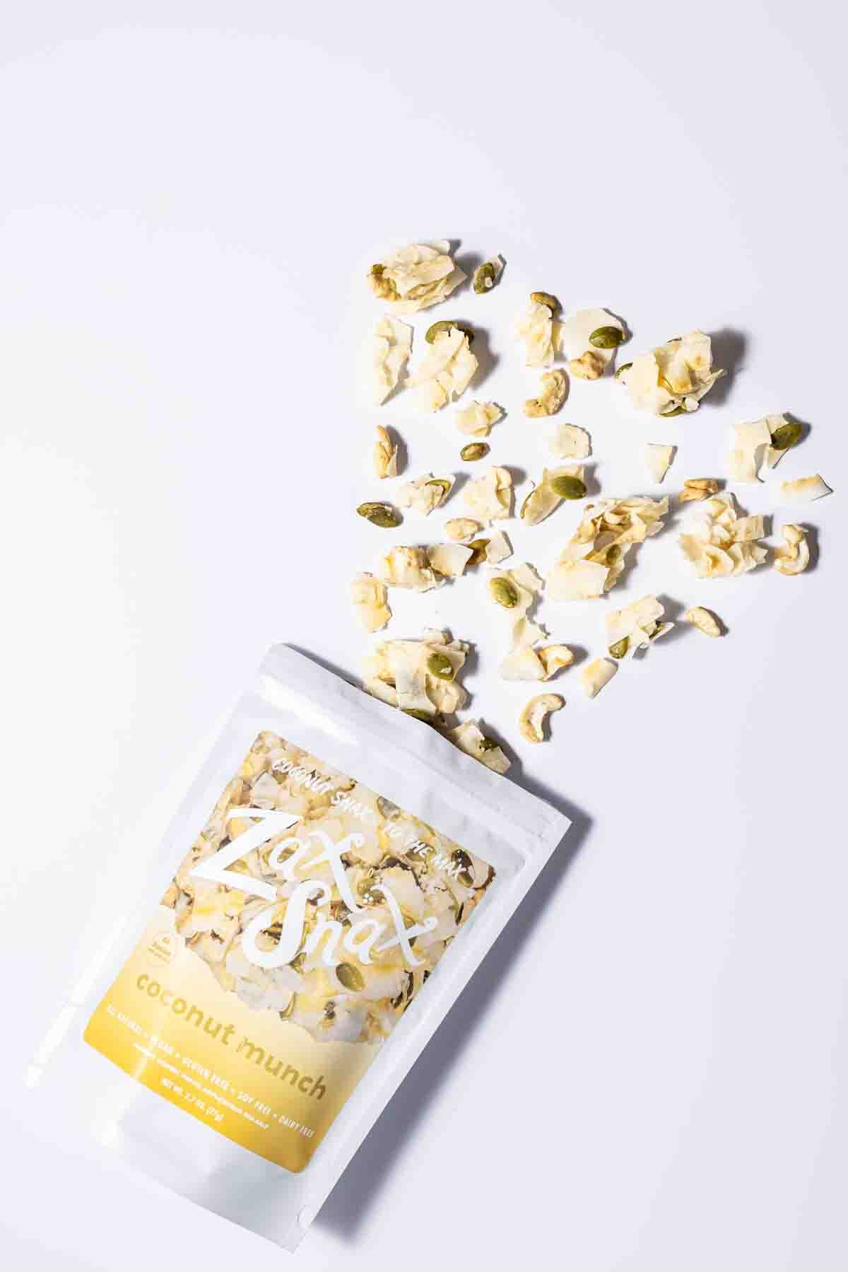 zaxsnax coconut much flavor snack coming out of a bag on white background